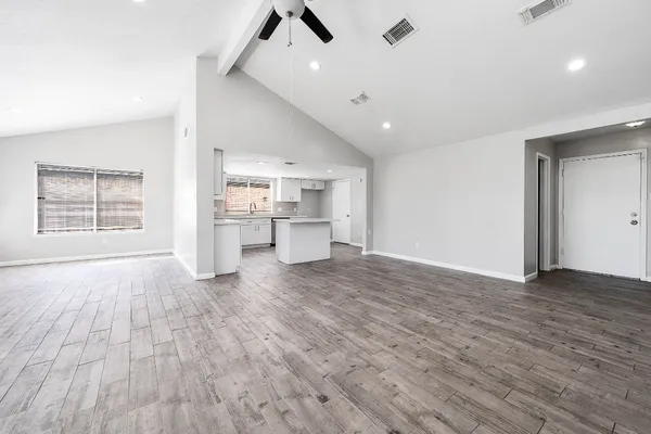 a view of empty room with wooden floor and window