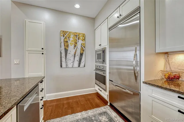 a kitchen with granite countertop stainless steel appliances a refrigerator and cabinets