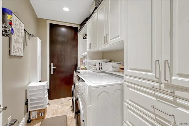 a utility room with cabinets washer and dryer