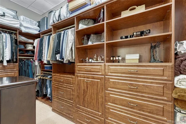a view of walk in closet with clothes and shoes