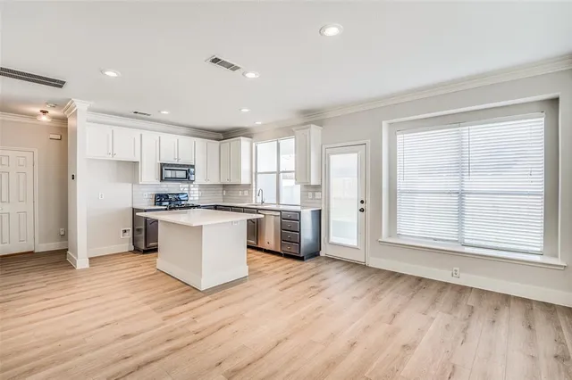 a kitchen with a refrigerator and white cabinets