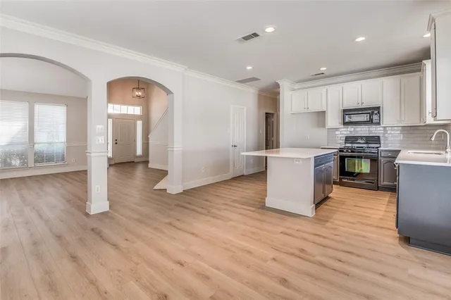 a large kitchen with cabinets and wooden floor
