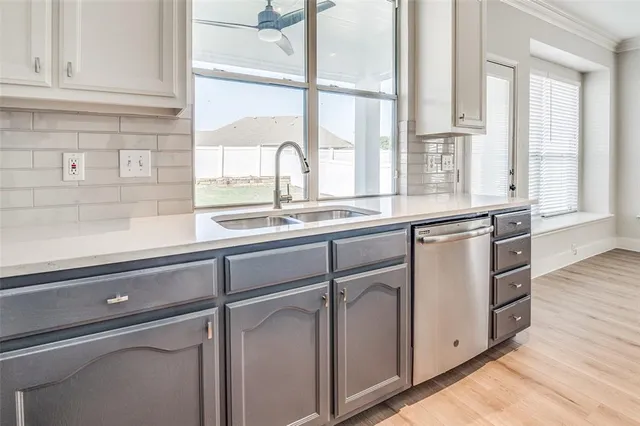 a kitchen with stainless steel appliances white cabinets and a window