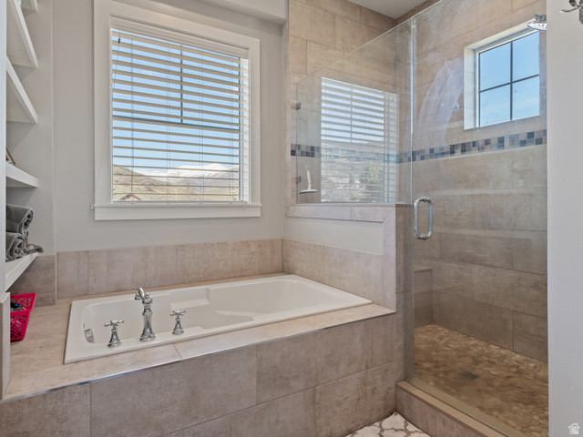 641 West 500 South Midway, UT 84049 - Photo 25 of 52 Built-in soaking tub with chrome fixtures, glass-enclosed shower with pebble floor, tile surround, accent tile band, and a window for natural light