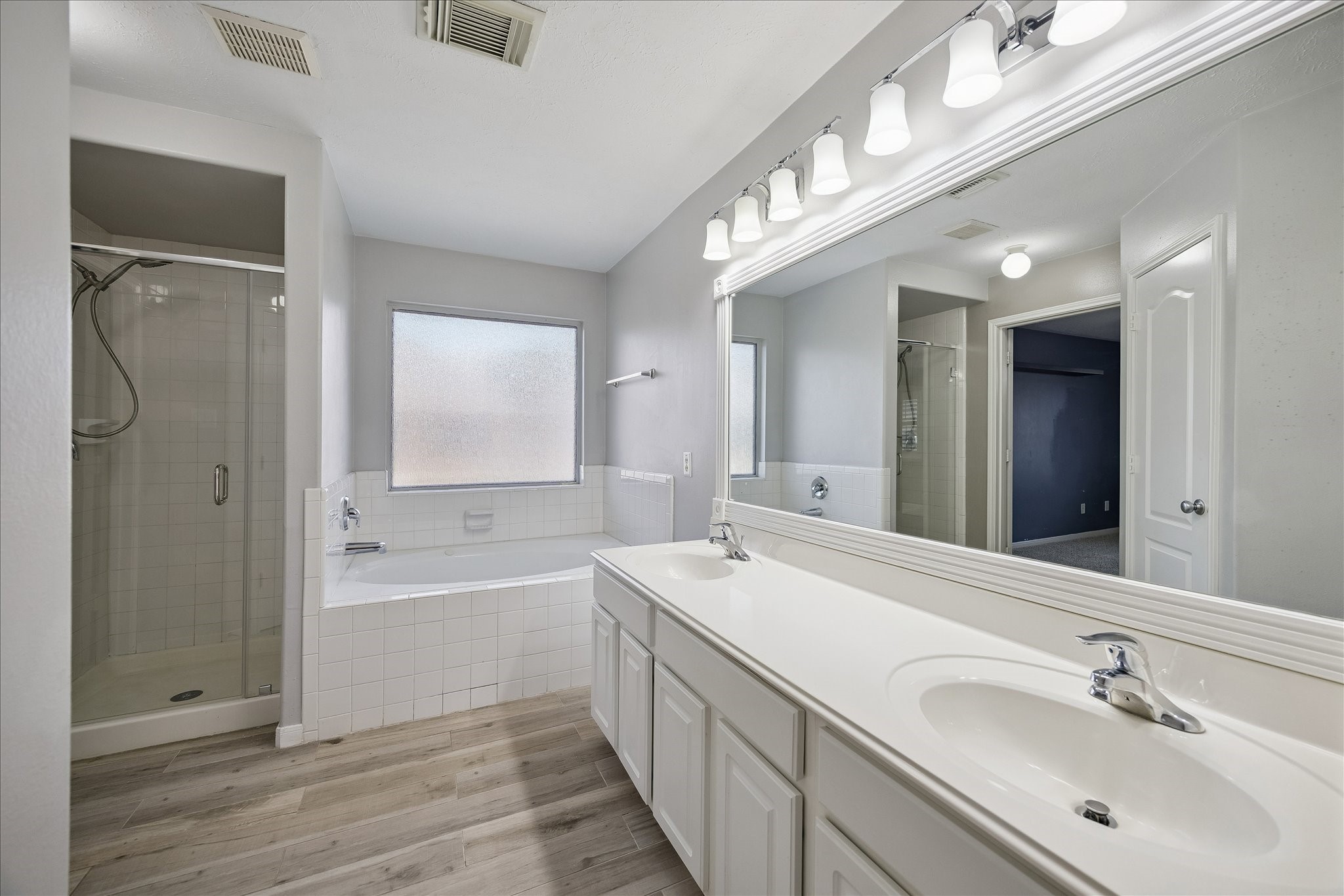 7403 Hollister Ridge Houston, TX 77040 - Photo 9 of 12 a spacious bathroom with a double vanity sink a mirror and a bathtub