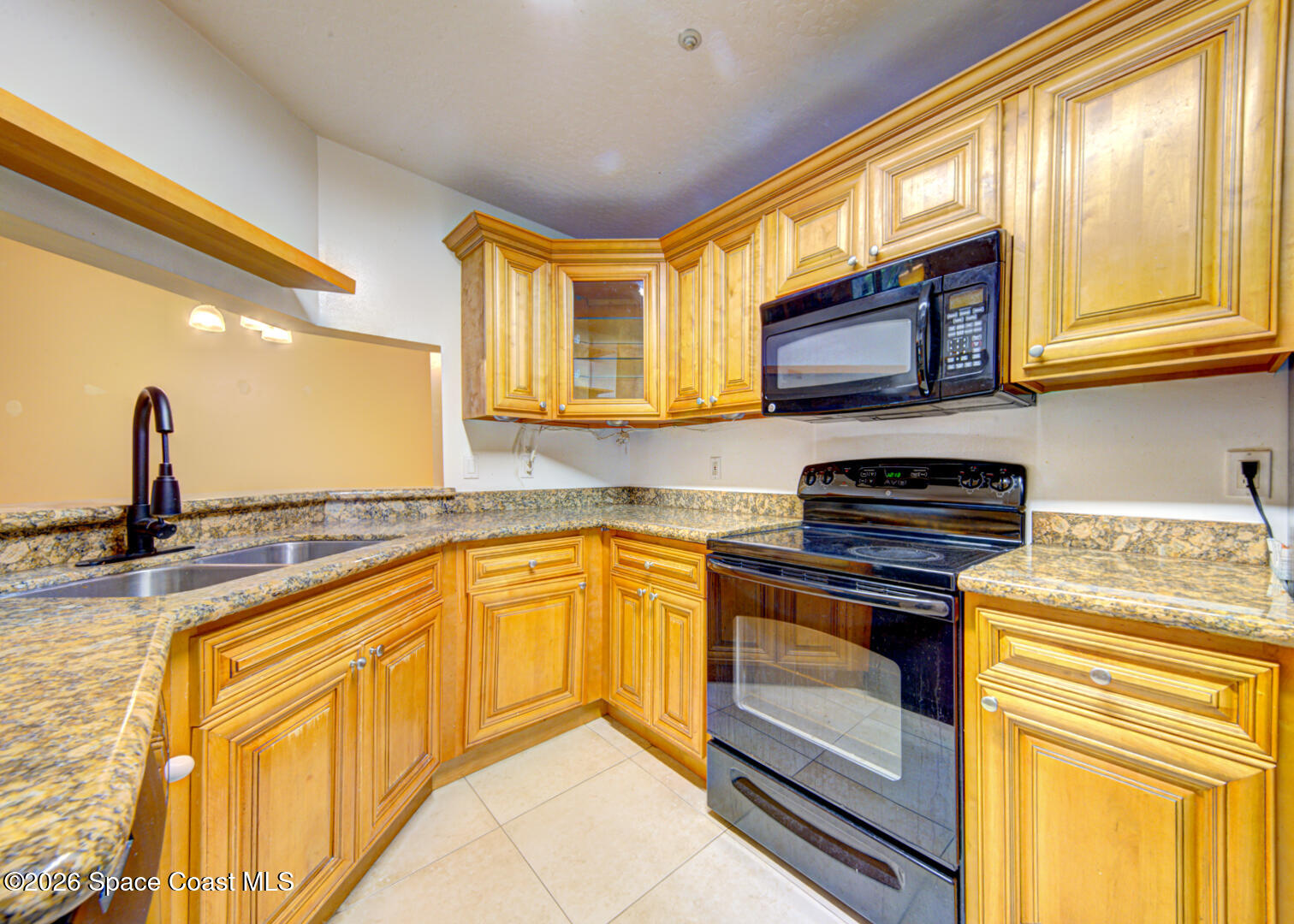 7667 North Wickham Road, Unit 1416 Melbourne, FL 32940 - Photo 7 of 41 a kitchen with stainless steel appliances granite countertop a sink and a microwave