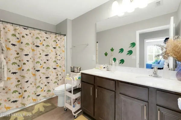 a bathroom with a mirror a double vanity sink and glass door shower