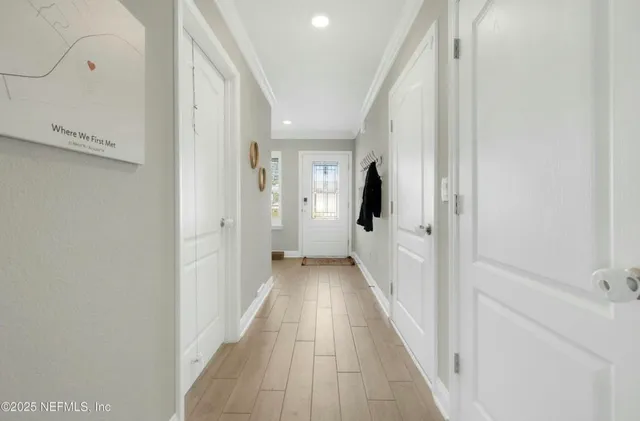 a view of a hallway with wooden floor and staircase