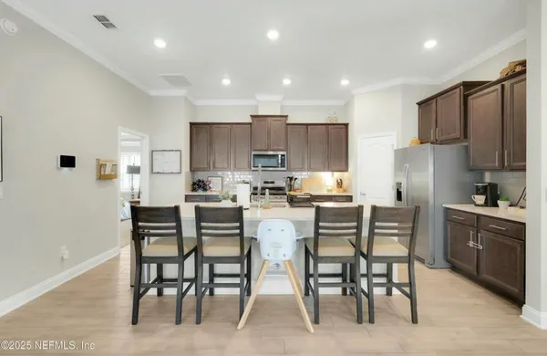 a kitchen with kitchen island wooden cabinets and stainless steel appliances