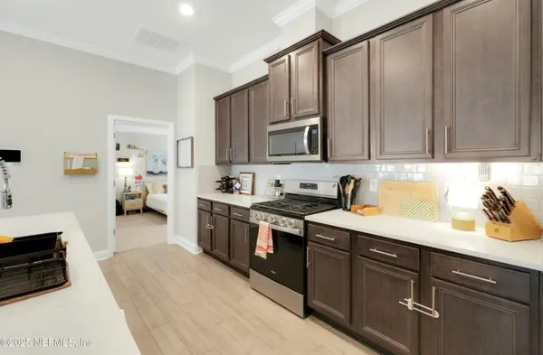 a kitchen with stainless steel appliances granite countertop a sink stove and cabinets