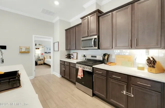 a kitchen with stainless steel appliances granite countertop a sink stove and cabinets