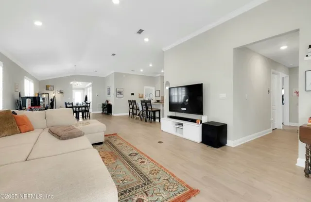 a large kitchen with stainless steel appliances a sink a stove a refrigerator cabinets and a dining table