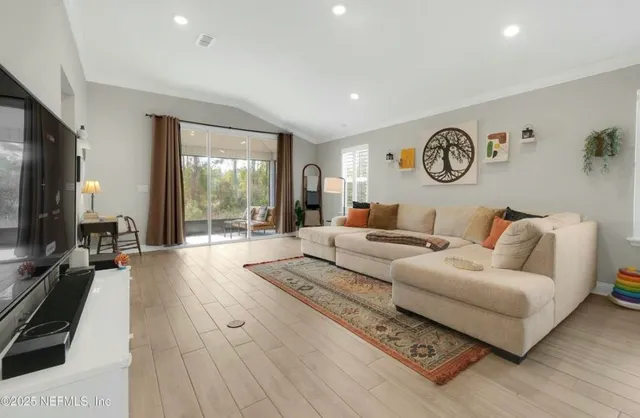 a living room with furniture a flat screen tv and kitchen view