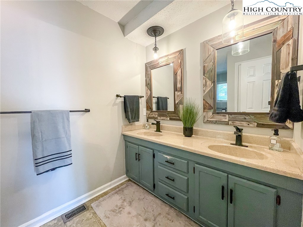 4850 US Highway 421 Vilas, NC 28692 - Photo 28 of 46 a bathroom with a double vanity sink and mirror