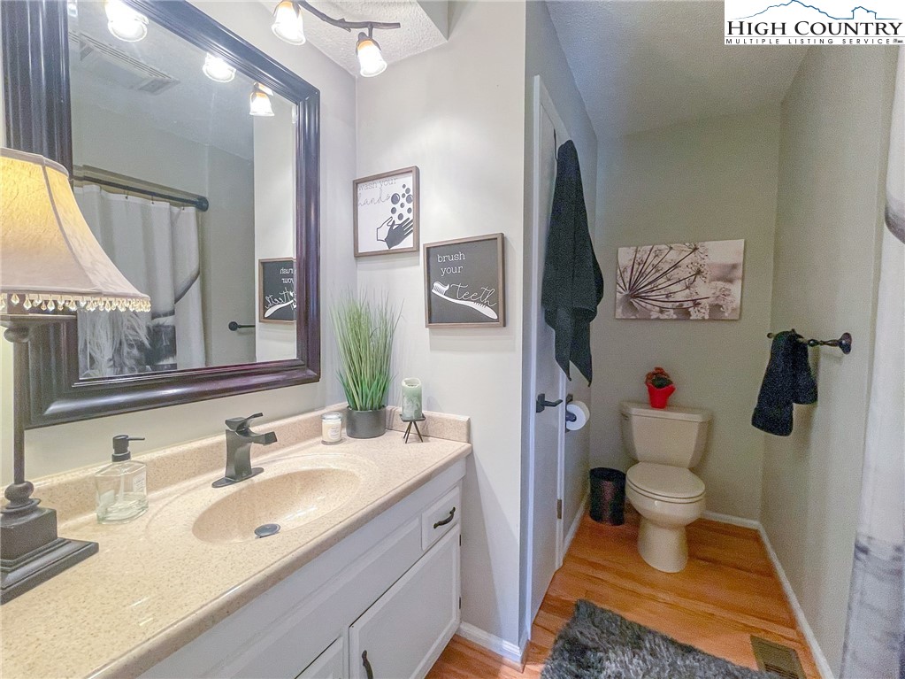 4850 US Highway 421 Vilas, NC 28692 - Photo 32 of 46 a bathroom with a granite countertop sink mirror vanity and toilet