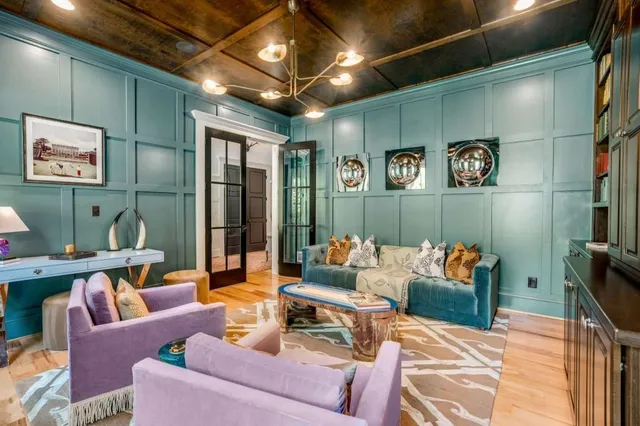 a living room with furniture a clock and a large window