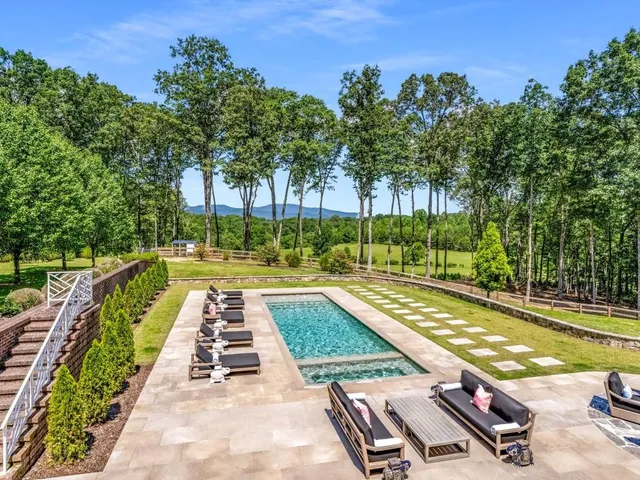 a view of an house with backyard and trees