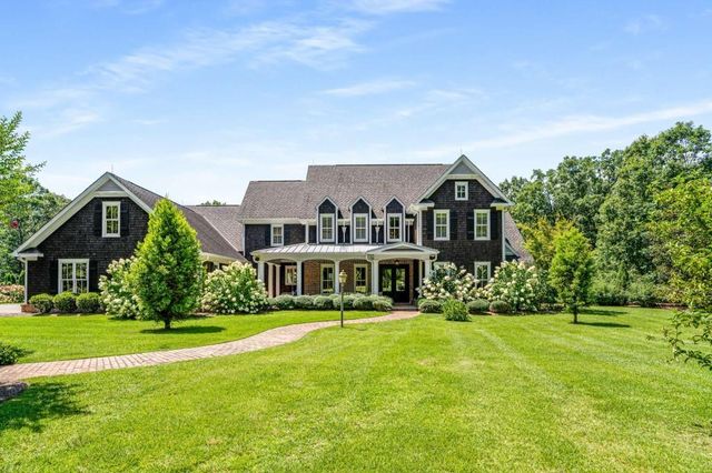 a kitchen with stainless steel appliances granite countertop a stove top oven a sink dishwasher a dining table and chairs with wooden floor