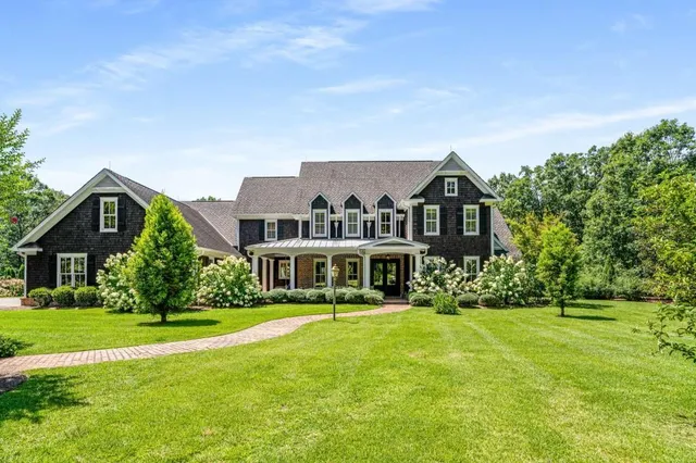 a kitchen with stainless steel appliances granite countertop a stove top oven a sink dishwasher a dining table and chairs with wooden floor