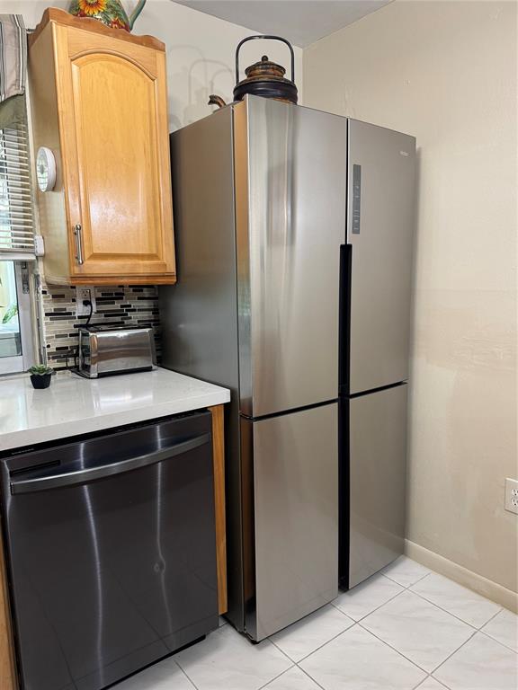 9400 Lime Bay Boulevard, Unit 112 Tamarac, FL 33321 - Photo 12 of 37 a kitchen with metallic refrigerator freezer and a dishwasher