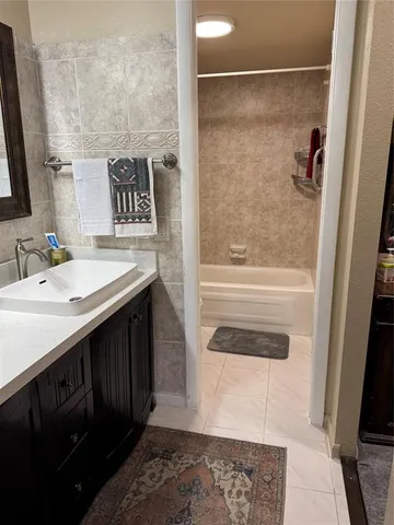 a bathroom with a sink and a mirror with bathtub