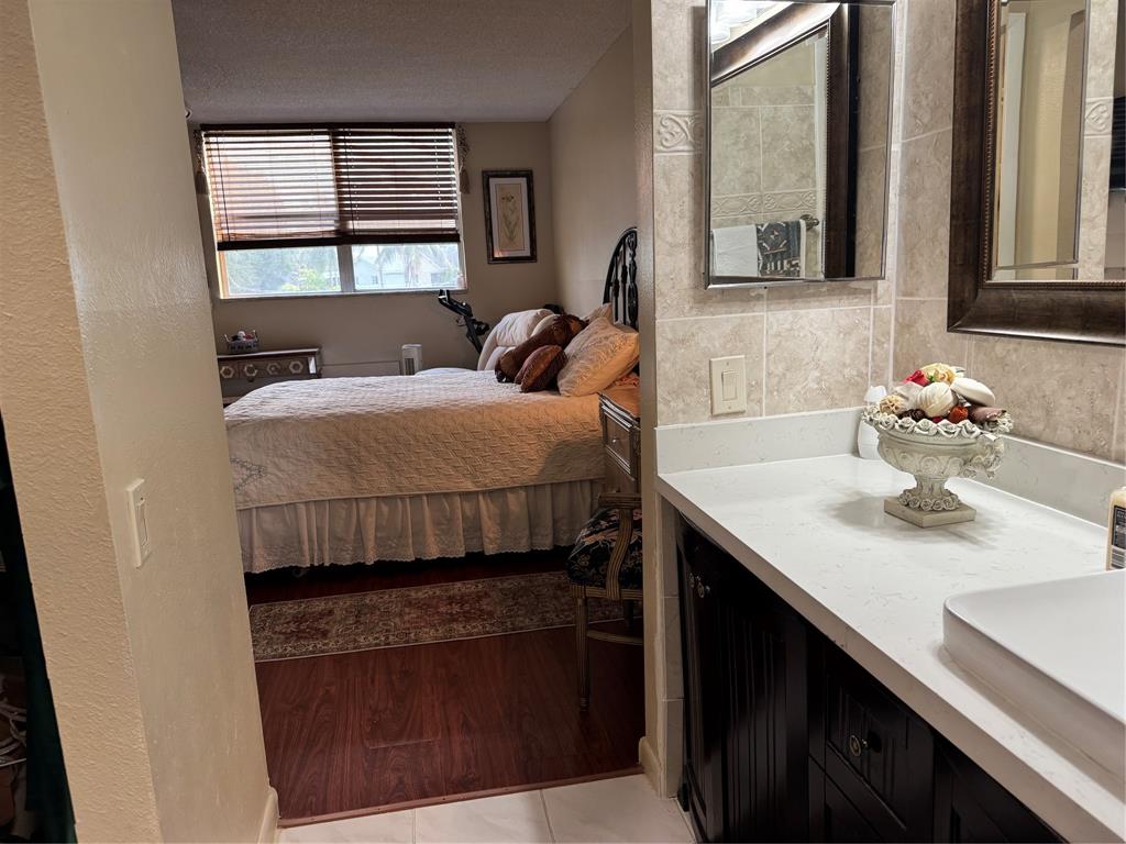 9400 Lime Bay Boulevard, Unit 112 Tamarac, FL 33321 - Photo 22 of 37 a bedroom with a bed and a window