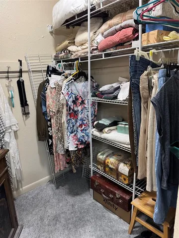 a view of walk in closet with clothes and shoes