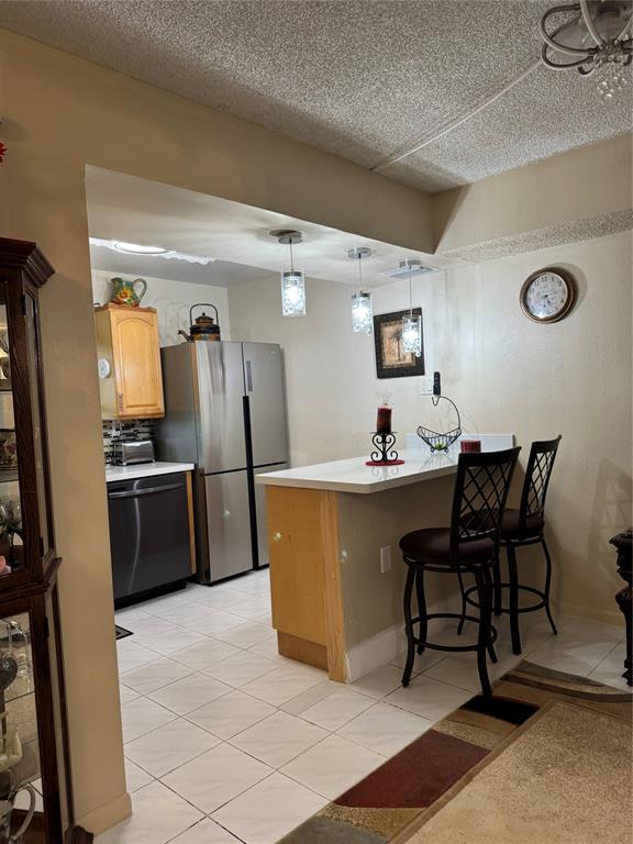 9400 Lime Bay Boulevard, Unit 112 Tamarac, FL 33321 - Photo 8 of 37 a kitchen with stainless steel appliances a refrigerator a stove a sink a dining table and chairs