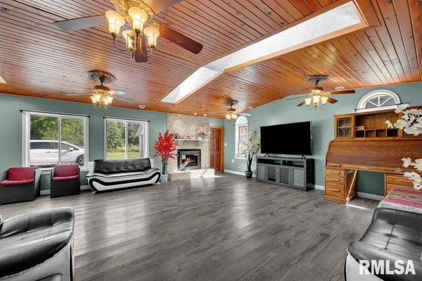 a living room with furniture a flat screen tv and a large window