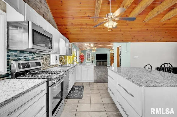 a kitchen with stainless steel appliances granite countertop a sink stove and cabinets