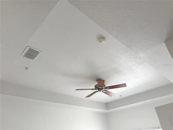 a view of a room with a ceiling fan and wooden floor