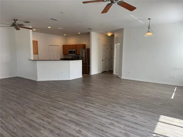 a view of kitchen with stainless steel appliances granite countertop a stove and a wooden floor