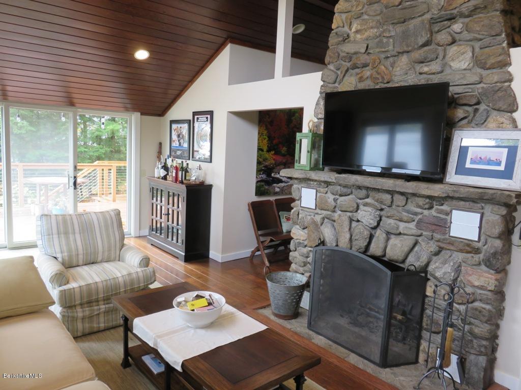 249 Old Pond Road Becket, MA 01223 - Photo 5 of 20 a living room with furniture a flat screen tv and a fireplace