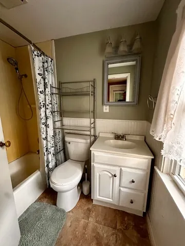 a bathroom with a granite countertop toilet sink and mirror
