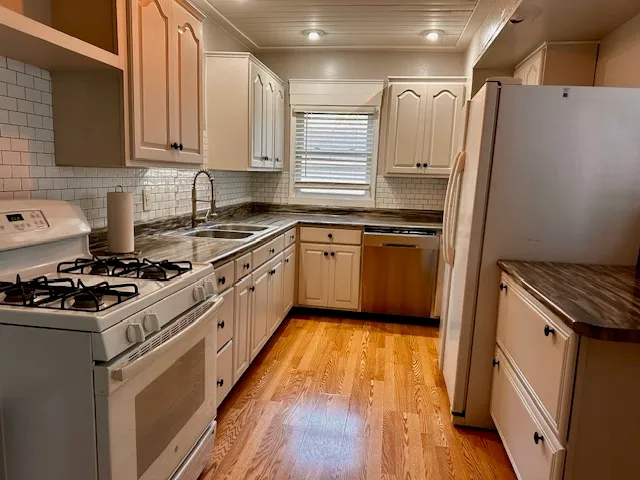 a kitchen with granite countertop a sink stove and refrigerator