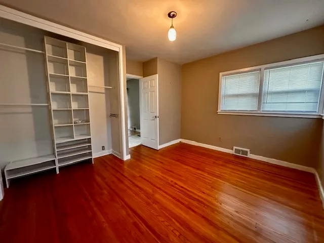 a view of empty room with wooden floor and window
