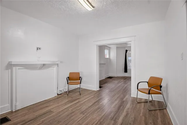 a view of a livingroom with wooden floor and a workspace