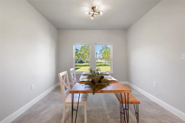 a dining room with furniture and a window