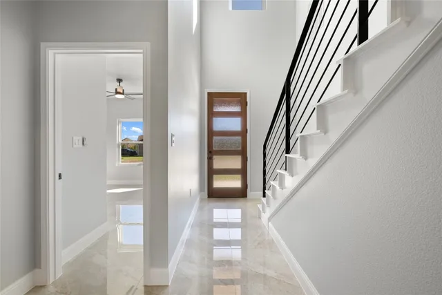 a view of a hallway with wooden floor and staircase
