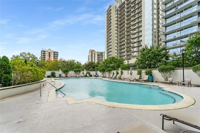 a view of a swimming pool with a terrace and sitting space