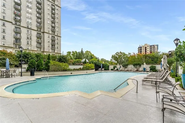 a view of a swimming pool with outdoor seating and plants