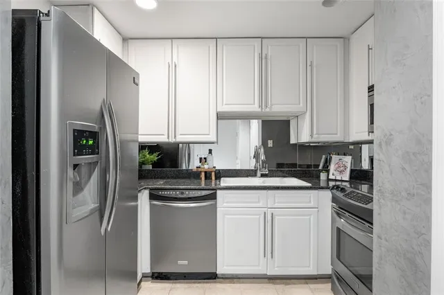 a kitchen with white cabinets and stainless steel appliances