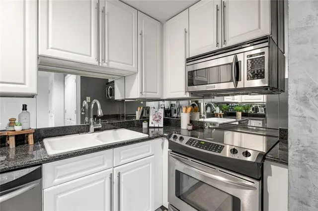 a kitchen with stainless steel appliances granite countertop a sink stove and cabinets