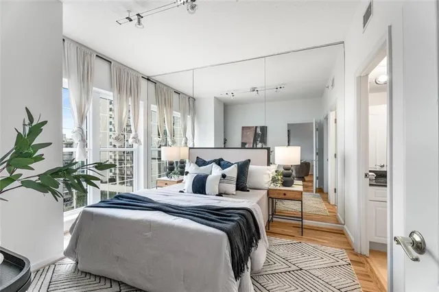 a bedroom with a large bed and a potted plant