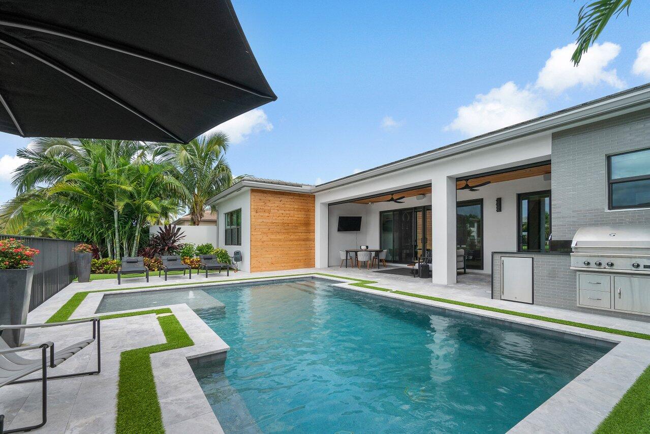 8581 Dearborn River Way Boca Raton, FL 33496 - Photo 27 of 53 a view of swimming pool with lawn chairs under an umbrella