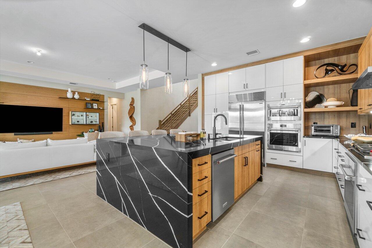 8581 Dearborn River Way Boca Raton, FL 33496 - Photo 8 of 53 a large kitchen with stainless steel appliances kitchen island granite countertop a stove and a sink