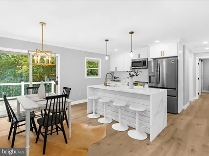 a kitchen with kitchen island a stove a table and chairs