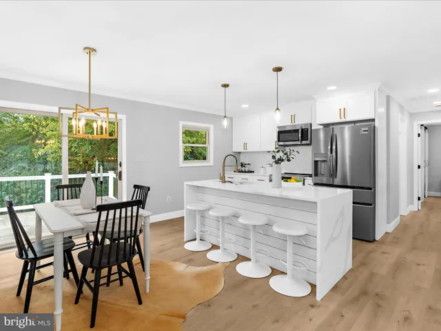 a kitchen with kitchen island a stove a table and chairs