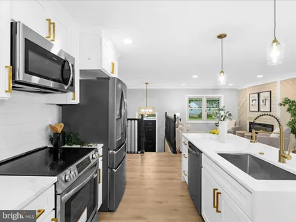 a kitchen with stainless steel appliances a stove microwave and sink