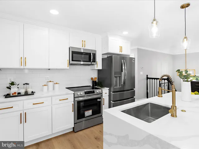 a kitchen with granite countertop a sink and steel appliances